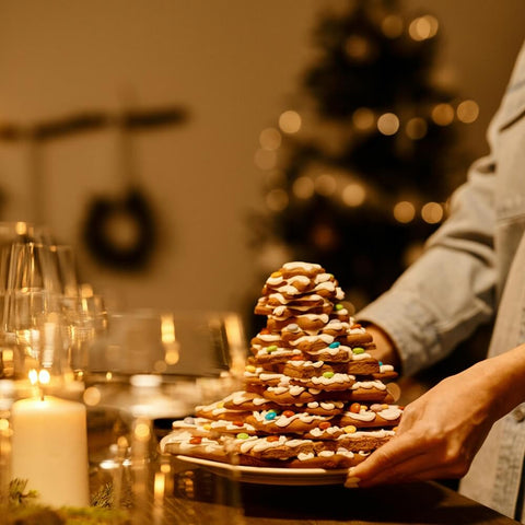 A person is carrying a gingerbread cookie Christmas tree, a reminder of toxic Christmas foods for dogs